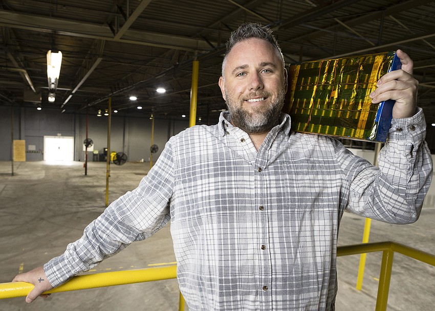 Nathan Staron holding a battery pack in a manufacturing facility